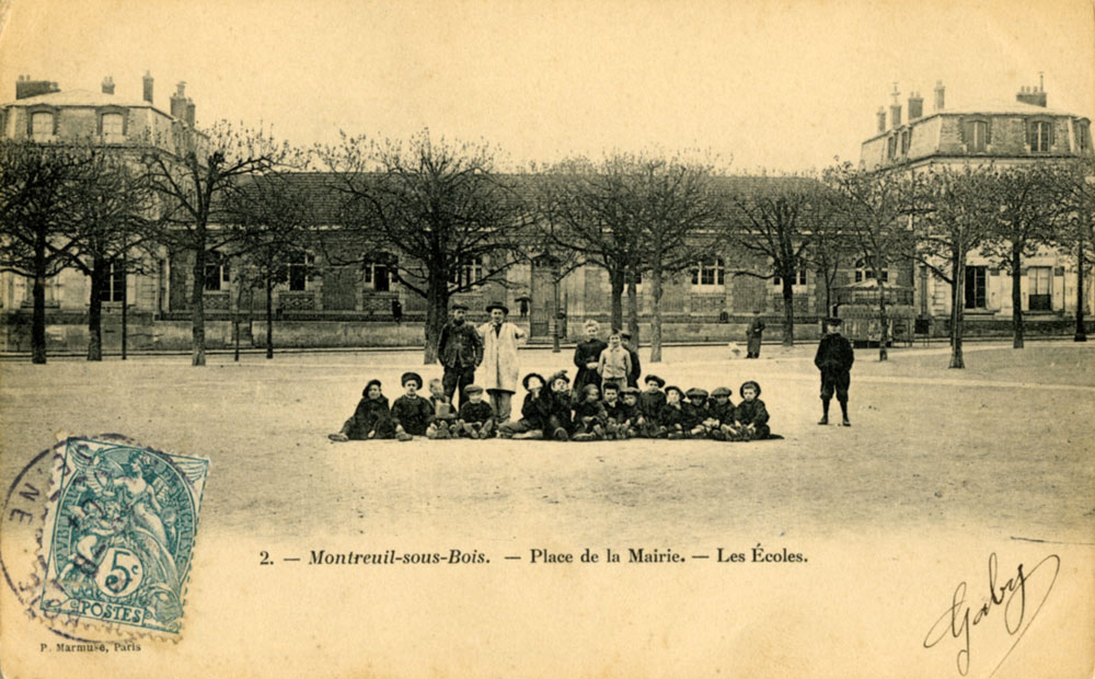 Écoliers posant sur la place Girard (aujourd’hui place Jean-Jaurès), devant l’école communale, au début du XXe siècle (carte postale) ©Coll. Musée de l’Histoire vivante